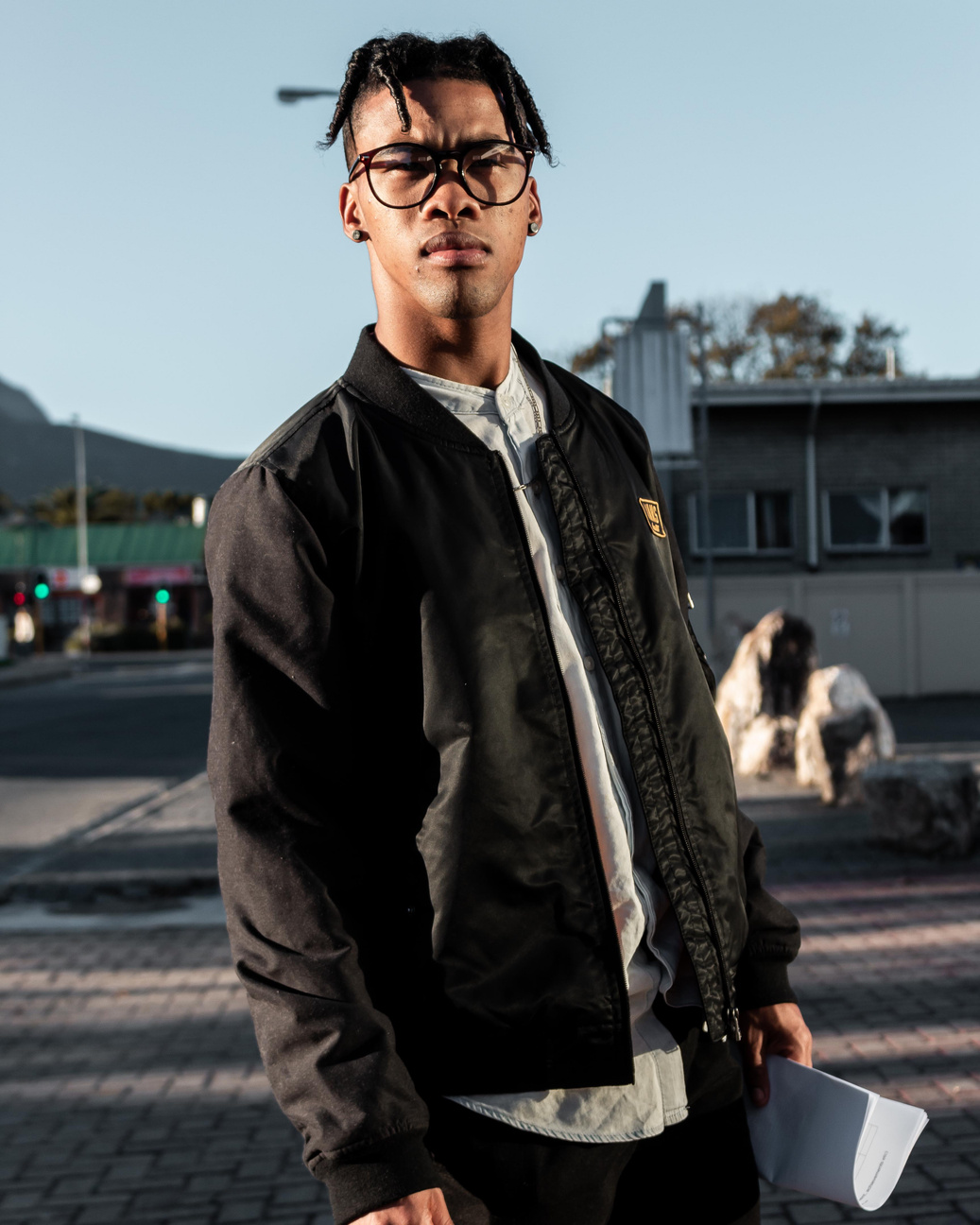 Man wearing black bomber jacket and black framed eyeglasses